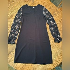 V-neck black dress with sheer floral sleeves with gold accents.